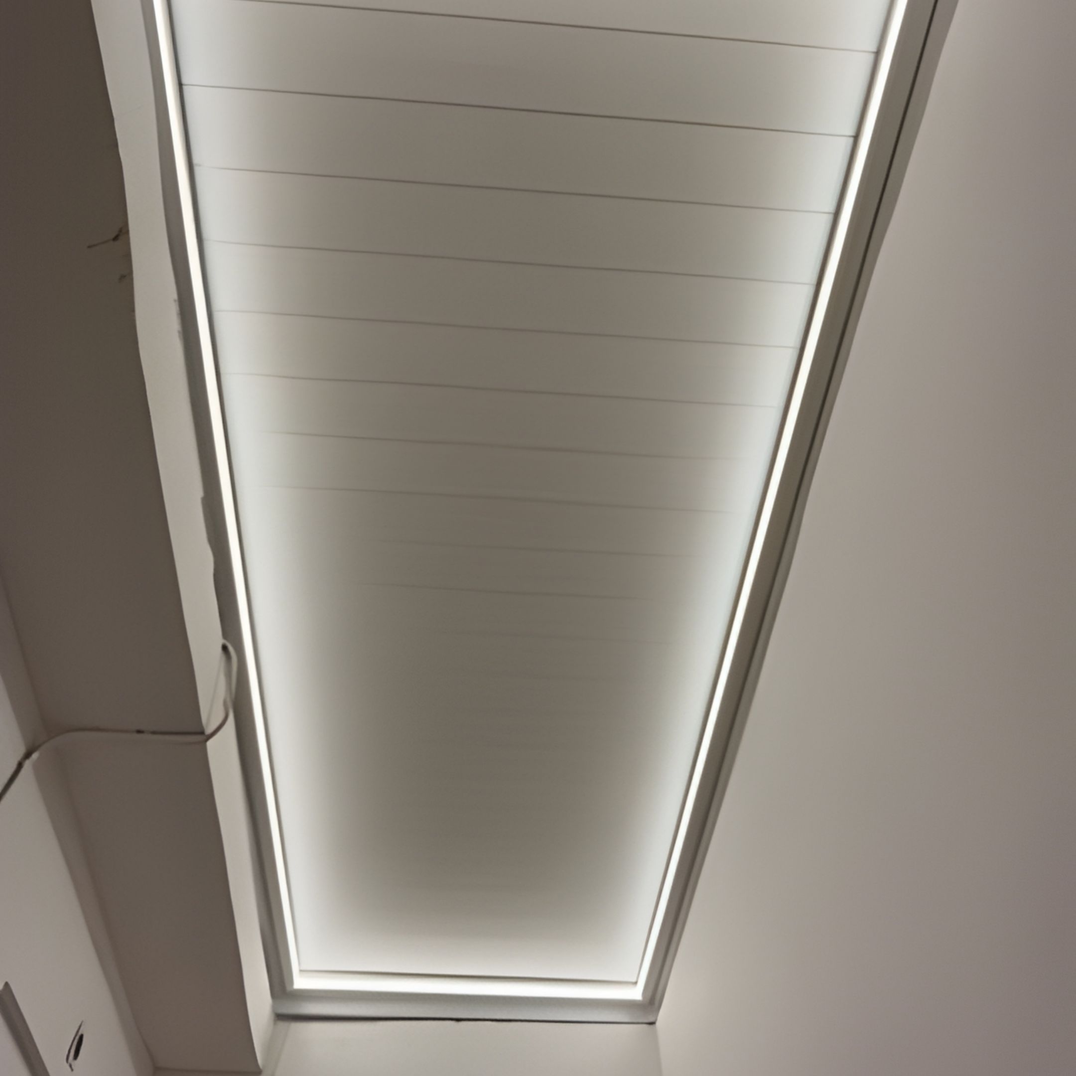 Βιοκλιματική ανοιγοκλειόμενη πέργκολα με κλειστές περσίδες και έντονο περιμετρικό LED φωτισμό σε εσωτερική αυλή στο Κερατσίνι