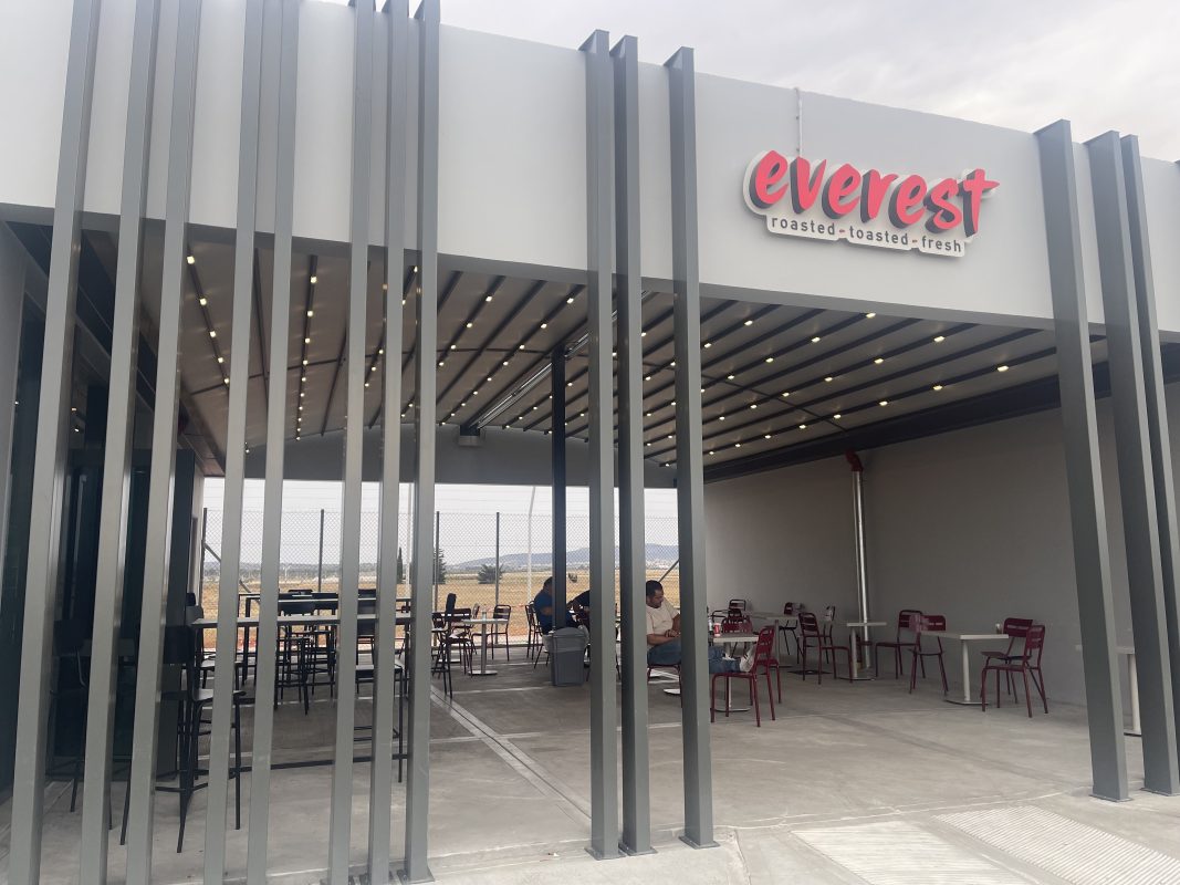 Κατάστημα Everest με μοντέρνο στέγαστρο εξωτερικού χώρου και φωτισμό LED. Προσφέρει σκίαση και ευχάριστο περιβάλλον για τους πελάτες.