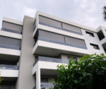 Πολυκατοικία με ενσωματωμένα συστήματα κάθετης σκίασης στα μπαλκόνια, ιδανικά για ενεργειακή απόδοση και αισθητική.