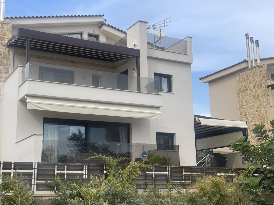 Μοντέρνα κατοικία με εγκατεστημένες πέργκολες και τέντες αλουμινίου για σκίαση και προστασία από τις καιρικές συνθήκες.