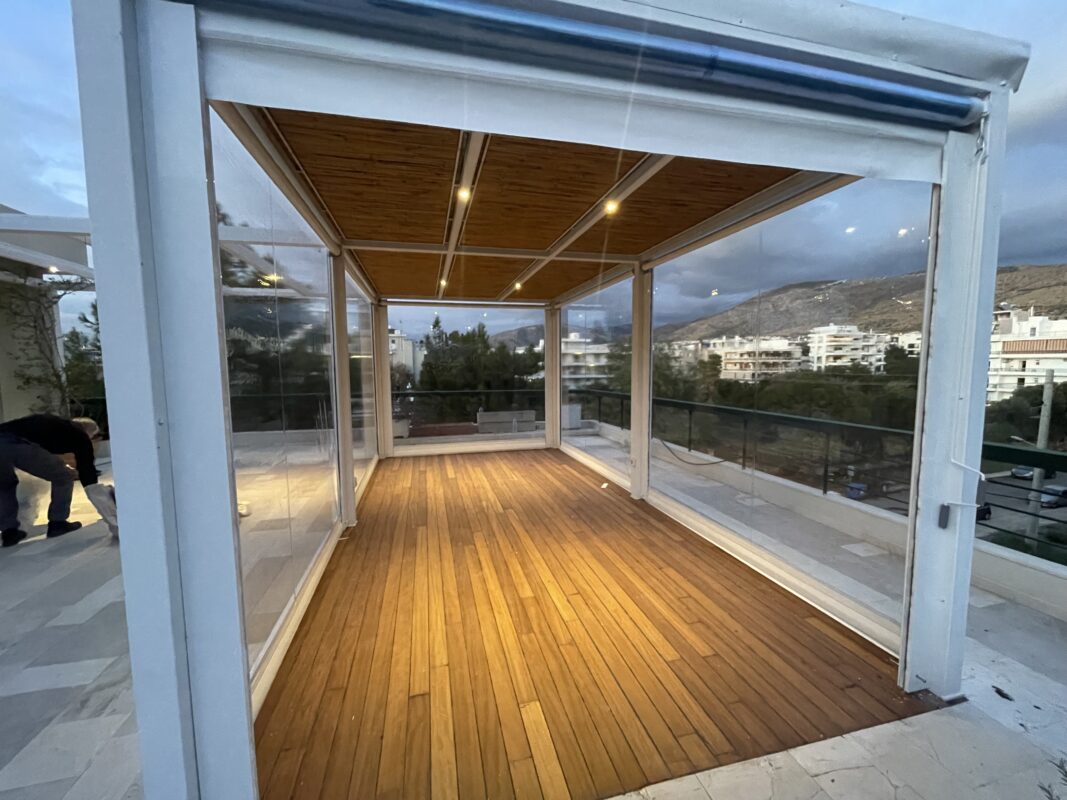Πέργκολα με πάνελ, κάθετα συστήματα σκίασης και ξύλινο δάπεδο, ιδανική για εξωτερικούς χώρους και όλες τις καιρικές συνθήκες.