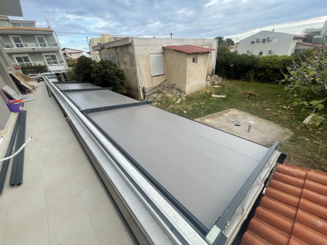 Άποψη τεντοπέργκολας εξωτερικού χώρου, με πτυσσόμενο σύστημα και ανθεκτικά υλικά, κατάλληλη για κάθε εποχή.