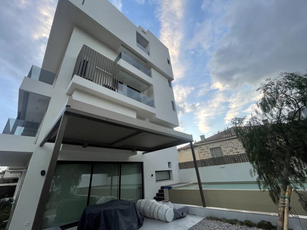 Εικόνα μιας ολοκληρωμένης εγκατάστασης βιοκλιματικής πέργκολας σε πολυτελή κατοικία, που αναβαθμίζει τον χώρο με λειτουργικότητα και στυλ.