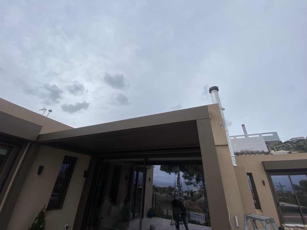Μοντέρνα βιοκλιματική πέργκολα ολοκληρωμένη, εναρμονισμένη με το περιβάλλον, ιδανική για προστασία και άνεση σε εξωτερικούς χώρους.