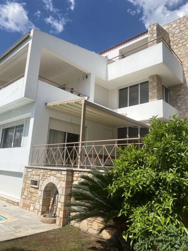 Εγκατάσταση τεντοπέργκολας αλουμινίου σε μοντέρνα κατοικία με πέτρινη επένδυση και πισίνα